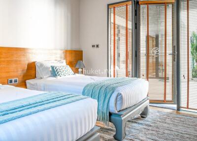 Modern bedroom with two single beds and a view of the patio