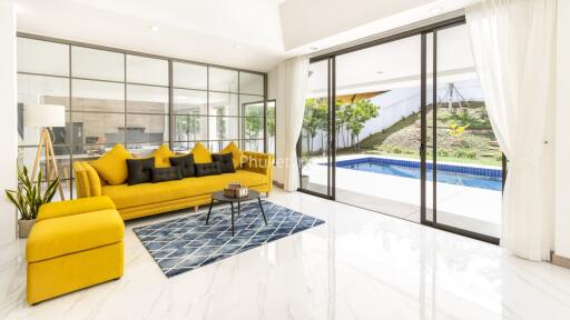 Spacious and bright living room with large glass doors leading to a pool and outdoor area