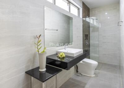 Modern bathroom with large mirror, sink, and shower