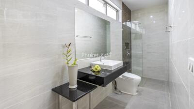 Modern bathroom with large mirror, sink, and shower