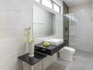 Modern bathroom with large mirror, sink, and shower