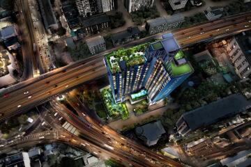 Aerial view of a modern building with rooftop gardens and surrounding cityscape