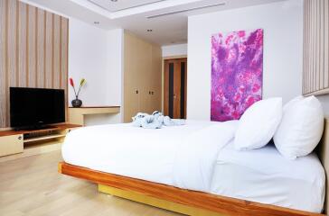 Modern bedroom with a wooden bed frame and artistic decor