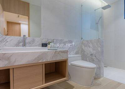 Modern bathroom with marble countertops and walk-in shower