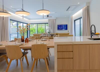 Modern open-plan kitchen and dining area with wooden furniture and large windows