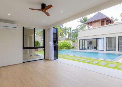 spacious living room with view of an outdoor pool and garden