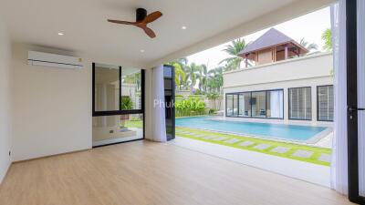 spacious living room with view of an outdoor pool and garden