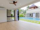 spacious living room with view of an outdoor pool and garden