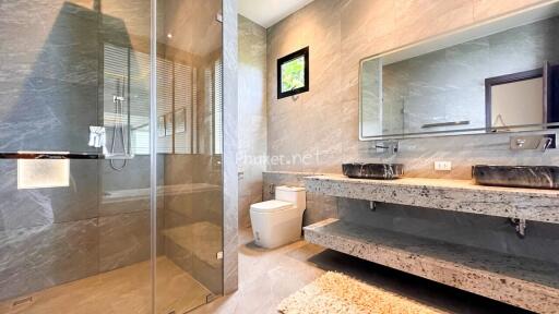 Modern bathroom with glass shower and dual vanity