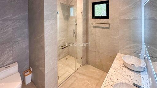 Modern bathroom with glass shower enclosure and dual sink vanity
