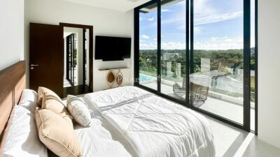 Modern bedroom with large glass door opening to a scenic balcony view