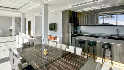 Modern kitchen with dining area featuring marble-top table and sleek bar stools