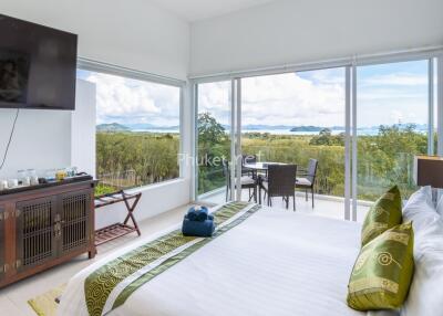 Bright bedroom with large windows showing a scenic outdoor view