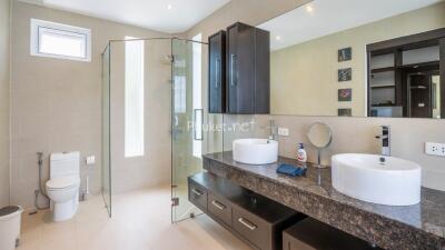 Modern bathroom with double sinks and glass shower