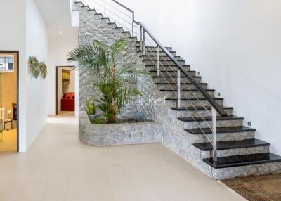 Modern indoor staircase with stone wall and decorative plants