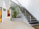 Modern indoor staircase with stone wall and decorative plants