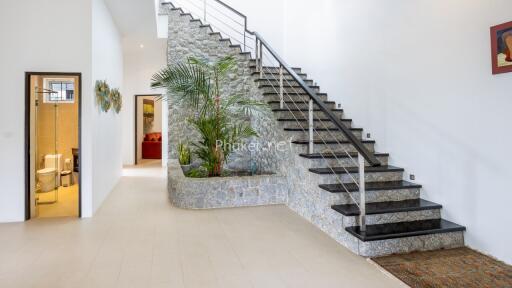 Modern indoor staircase with stone wall and decorative plants