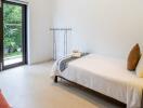 A minimalist bedroom with single bed, side table, and a large window with a view of greenery.