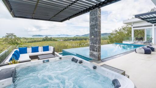 Luxurious outdoor area with jacuzzi, infinity pool, and scenic view