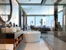 Modern bathroom with glass shower, large bathtub, and double sink