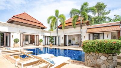 Outdoor pool area with sun loungers and palm trees