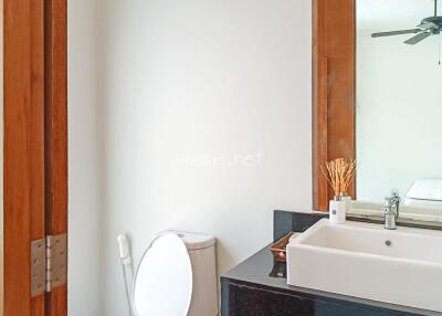 Modern bathroom with mirror, sink, and wooden-framed door