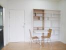 Minimalist dining area with white table and wooden chairs