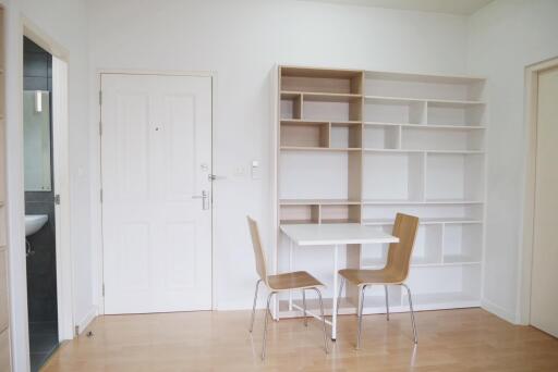 Minimalist dining area with white table and wooden chairs