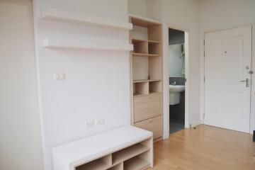 Living area with storage and view into bathroom