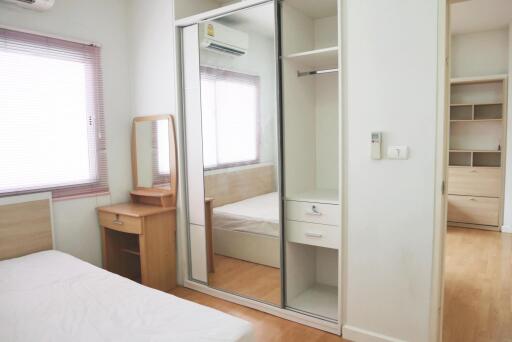 Bright bedroom with mirrored closet and wooden furnishings