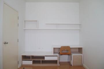 Modern and minimalistic bedroom with desk and shelving.