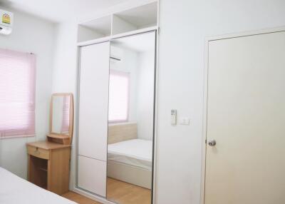 Bright bedroom with air conditioning, mirrored wardrobe, and natural light.