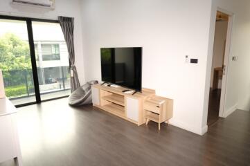 Modern living room with large TV and wooden furniture