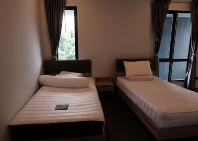 Bedroom with two single beds, window, and curtains