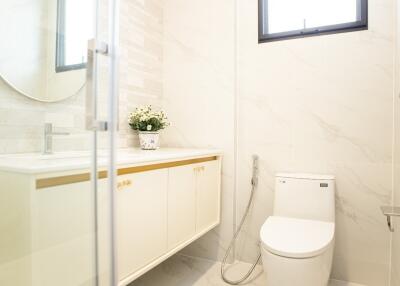 Modern bathroom with a toilet, vanity, and mirror