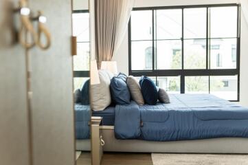 Modern bedroom with large windows and blue bedding