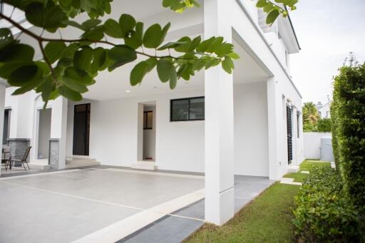 Modern house exterior with covered patio and greenery