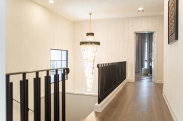 Elegant hallway with chandelier and staircase