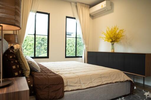 Spacious bedroom with window view and air conditioning
