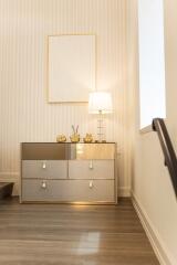 Well-lit hallway with decorative chest and lamp