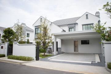 Modern white house with large driveway and garden