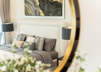 Modern well-decorated bedroom with a mirror, lamps, and a bed with throw pillows