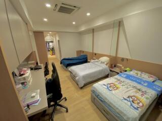 Spacious bedroom with two beds, working desk, and air conditioning