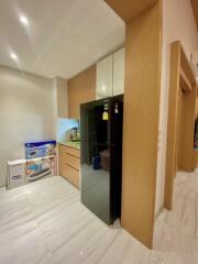 Modern kitchen with light wood cabinets and black refrigerator