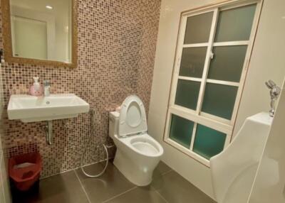 Modern bathroom with sink, toilet, urinal, and mosaic tiled wall