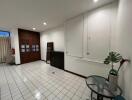 Main living area with tiled floor, large windows, and wooden cabinets