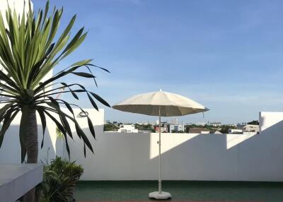 Spacious terrace with a large umbrella and plants