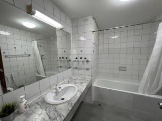 Modern bathroom with white tiles and a marble countertop