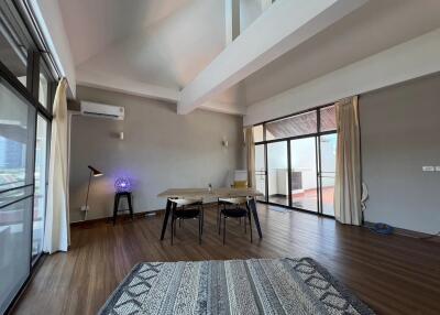 Spacious living room with wooden floor, modern furniture, and large windows