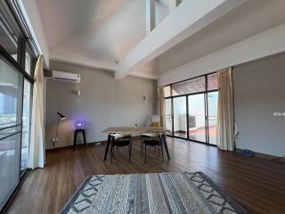 Spacious living room with wooden floor, modern furniture, and large windows